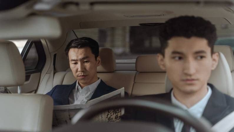 Two Men in White Suit Sitting Inside Car